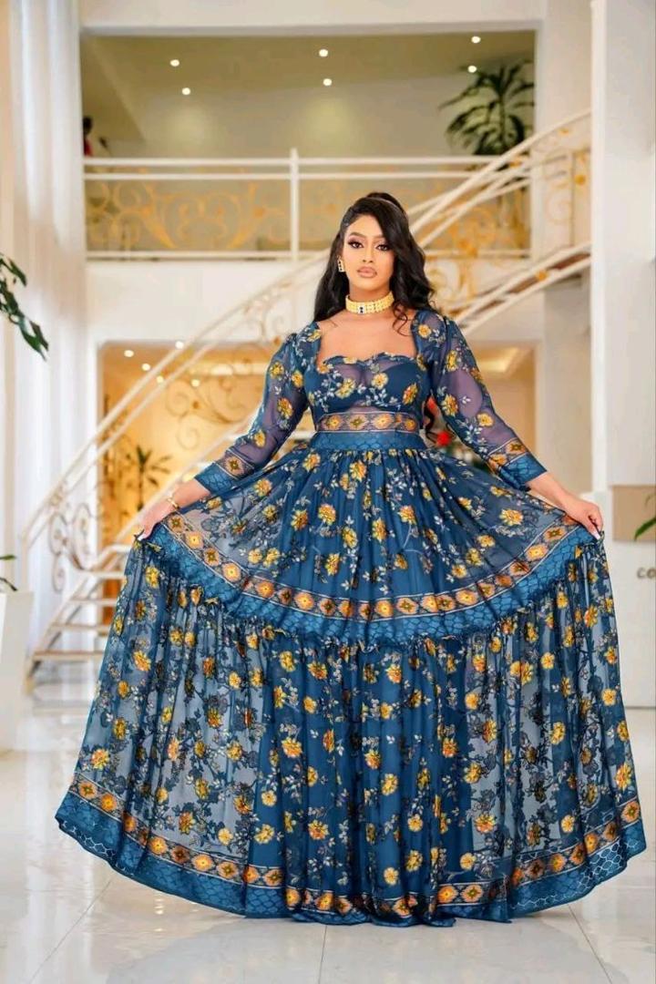 Woman in a blue floral dress standing in a well-lit indoor setting, 🇪🇹 Shefon Elegance: Modern Ethiopian Chiffon for the Holidays