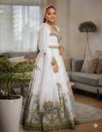 Emerald Elegance: White Ethiopian Habesha Kemis with Green & Gold Tillet Embroidery | ETH_Wm - 0001Women'sKaba StoreKaba StoreXSAll agesWoman in a white and green embroidered traditional outfit. Ethiopian wedding Habesha brides  Ethiopian Embroidery Colors Tilet for Epiphany/Baptism Tilet Color Occasion Kaba Store Products Kaba Store Heritage Tilet Color Meaning Habesha Tilet Guide Habesha Style Gallery Habesha Kemi Symbolism Habesha Embroidery Motifs Ethiopian Wedding Style Ethiopian Wedding Co